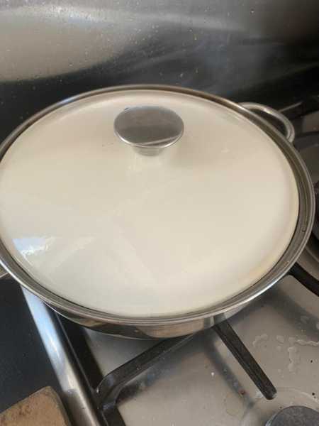 A pan with lid on a gas hob